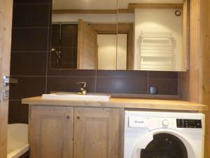 een badkamer met een wasmachine en een wastafel bij Nogentil in Saint-Bon-Tarentaise