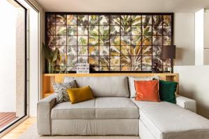 - un salon avec un canapé gris et des oreillers colorés dans l'établissement Janika's Patio, à Porto