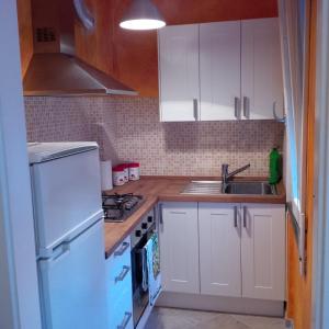 eine kleine Küche mit weißen Schränken und einem Waschbecken in der Unterkunft Casa Emily in Marinella di Sarzana