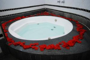 a bath tub with red roses around it at Mirage Motel Guarulhos in São Paulo +18 photos