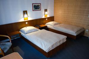 two beds in a room with two tables and two lamps at Zur Rennbahn in Drage
