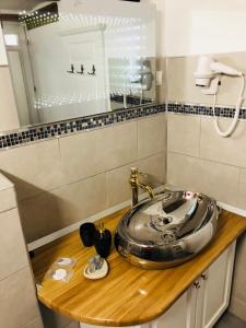 baño con lavabo de plata en una encimera de madera en V. Apartment, en Sighişoara