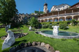 a building with a fountain in the middle of a yard at Romantik Hotel Turm in Fi&egrave;