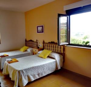 a bedroom with two beds and a window at O Cruceiro in Lires