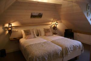 een slaapkamer met een groot bed op zolder bij Bakhuis Bij Hoestinkhof in Markelo