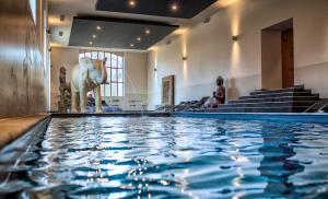 een zwembad met een olifantenbeeld in een gebouw bij The Originals le Château de Dissay Poitiers in Dissay
