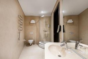 uma casa de banho com um lavatório, um chuveiro e um WC. em Amberton Cathedral Square Hotel Vilnius em Vilnius