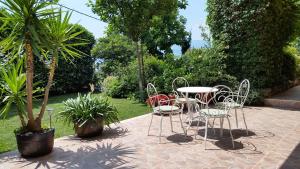 a patio with a table and chairs and a palm tree at AURELIO in Rijeka