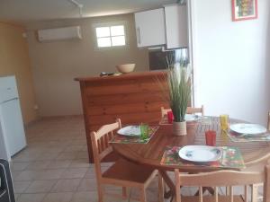 a kitchen with a wooden table with chairs and a dining room at GÎTE MORINGA in Bouillante