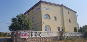 a large building with a sign in front of it at Apartmani Gabi in Cesarica