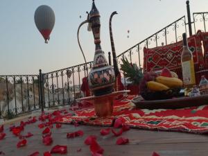 a table with red rose petals on the ground with a hot air balloon at Milat Cave Hotel in Göreme