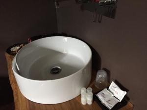a white sink on a wooden counter in a bathroom at Itaka in LʼAquila