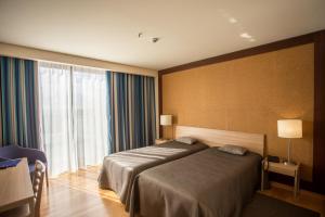 Postel nebo postele na pokoji v ubytování Antillia Hotel