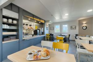 - une salle de petit-déjeuner avec une table et une assiette de nourriture dans l'établissement B&B HOTEL Marseille Estaque, à Marseille