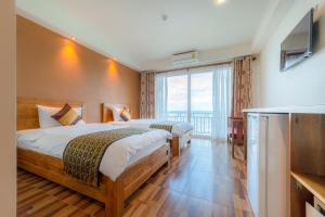 een hotelkamer met 2 bedden en een groot raam bij The Lord Nelson Hotel in Ban Chang