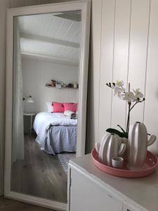 una camera con un letto e un grande specchio di Olsens Pensjonat a Veiholmen