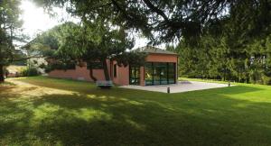 un parc avec un bâtiment avec un banc dans l'herbe dans l'établissement Hotel Du Donon, à Grandfontaine