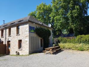 een gebouw met een houten bank ervoor bij Logis Relais Des Caillères in Saint Pavace