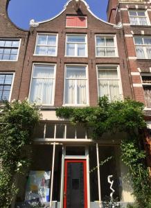 a large brick building with a red door at Casa Luna in Amsterdam