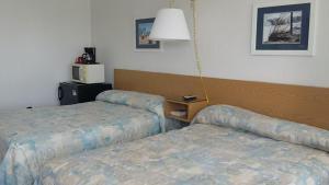 سرير أو أسرّة في غرفة في Tide Winds Motel