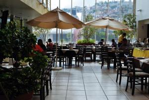 un restaurante con gente sentada en mesas y sombrillas en Hotel Mediterraneo Sa De Cv, en Tulancingo