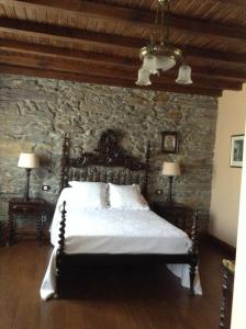 a bedroom with a bed in a stone wall at Casa Portela in Portela de Portomourisco