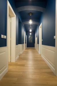 an empty hallway with blue walls and wooden floors at Trieste 411 - Rooms & Apartments in Trieste