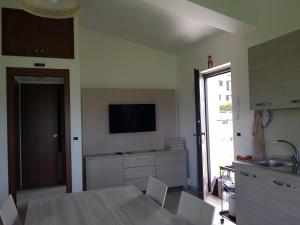 タリアコッツォにあるIl paradiso d'Oriente!のキッチン(テーブル付)、壁掛けテレビが備わります。