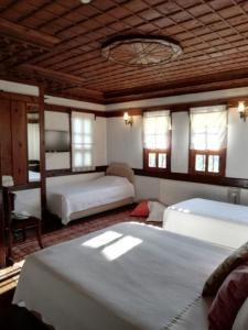 a bedroom with two beds and a wooden ceiling at Turgut Reis Konak in Safranbolu