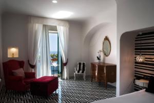 a bedroom with a bed and a desk and a chair at Hotel Montemare in Positano