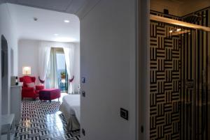 a hallway with a room with a bed and a red chair at Hotel Montemare in Positano