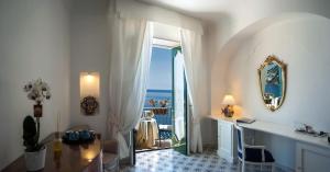 a room with a desk and a view of the ocean at Hotel Montemare in Positano