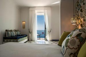 a bedroom with a bed and a view of the ocean at Hotel Montemare in Positano