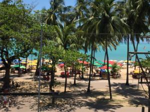 una playa con palmeras y un parque infantil en Apartamento Studio na Beira Mar de Pajuçara - todo reformado, en Maceió