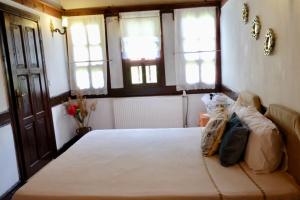 a bedroom with a large bed with windows and a couch at Turgut Reis Konak in Safranbolu