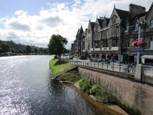 a river in a town with buildings next to it at Silver Key Apartments in Inverness