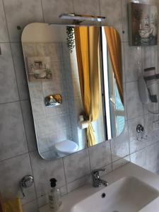a bathroom with a sink and a mirror at Appartamenti Antica Salaria in San Benedetto del Tronto