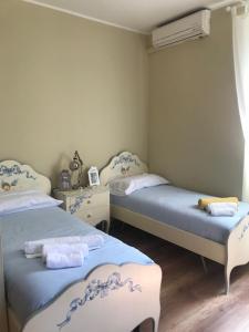 two beds in a room with blue and white at Appartamenti Antica Salaria in San Benedetto del Tronto