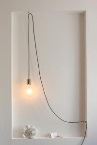 a light fixture hanging from a white wall at Dimora Marinucci in Termoli