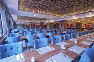 YolcatıにあるBolu Koru Hotels Spa & Conventionの青い椅子とテーブルのあるレストランのダイニングルーム