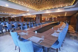YolcatıにあるBolu Koru Hotels Spa & Conventionの長テーブルと青い椅子が備わるレストラン +58枚の写真
