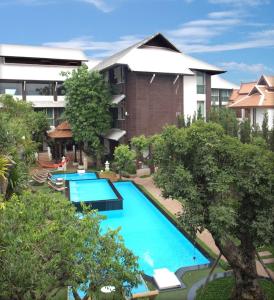 una vista aérea de una piscina frente a un edificio en Kodchasri Thani Hotel Chiangmai - SHA Extra Plus, en Chiang Mai