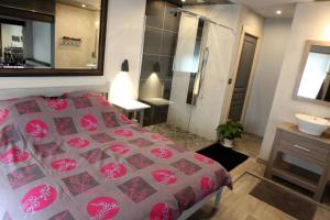 ein Schlafzimmer mit einem Bett und ein Badezimmer mit einem Waschbecken in der Unterkunft Le cocon des lacs in Boussu-lez-Walcourt