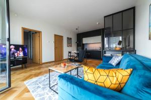 un soggiorno con divano blu e tavolo di Modern Luxury Apartment in City Centre a Tallinn