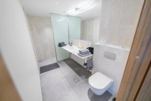a white bathroom with a toilet and a sink at Modern Luxury Apartment in City Centre in Tallinn