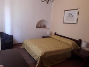 um pequeno quarto com uma cama e uma cadeira em A Casa Di Tuccio em Viagrande