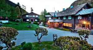 a large wooden building with a courtyard in front of it at Elveseter Hotell in Boverdalen +44 photos