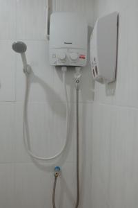 a shower in a bathroom with a hair dryer at JD hostel in Phra Nakhon Si Ayutthaya