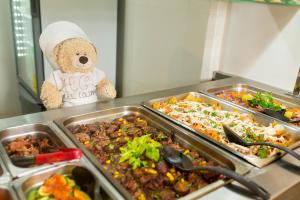a teddy bear standing next to a buffet of food at Hotel Colonial de Merida in Mérida