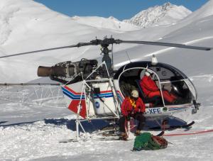 Zwei Leute sitzen in einem Hubschrauber im Schnee. in der Unterkunft Chasa Val Bella in Samnaun
